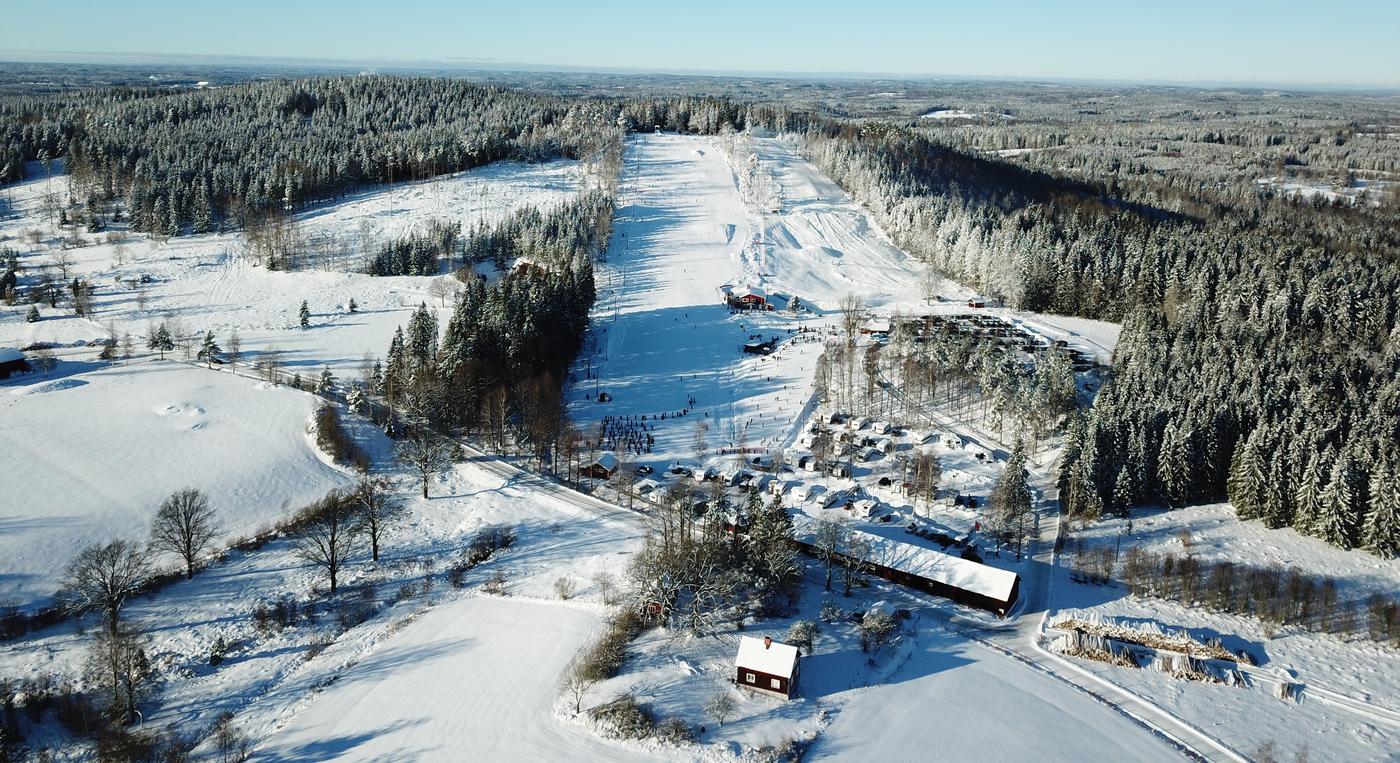 En liten camping syns nedanför en skidbacke.