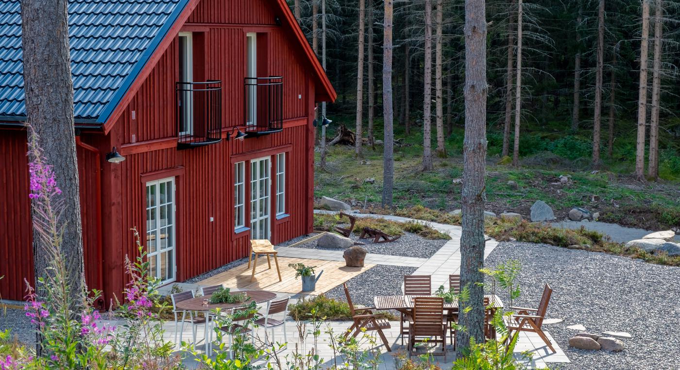 Ett rött hus i skogen med en fin uteplats