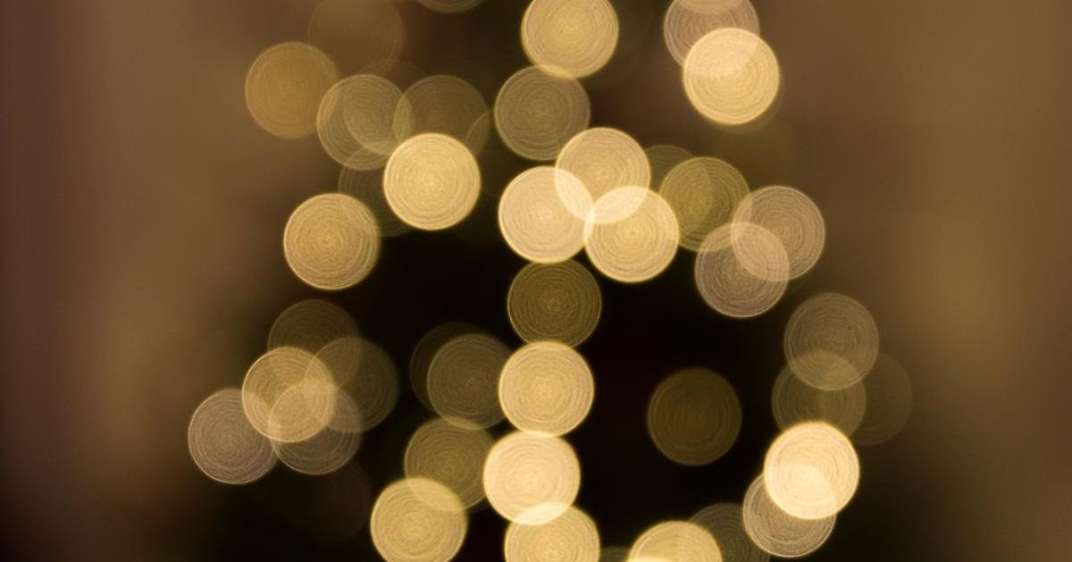 Julgran med ljus, sett på avstånd utan fokus i bilden.