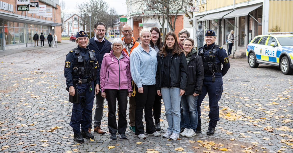 En grupp människor, bland annat två med polisuniform, står i en grupp.