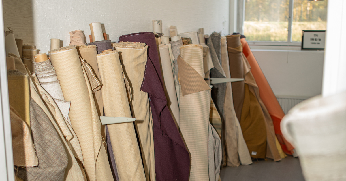 Rullar med tyger står lutade mot en vägg.