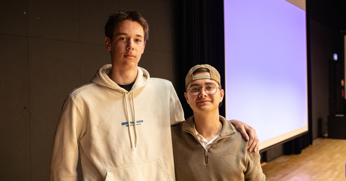 Två män står bredvid varandra framför en projektorduk.