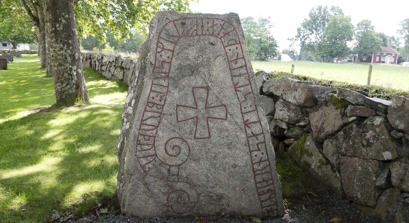 En stor runsten med ett kors på.
