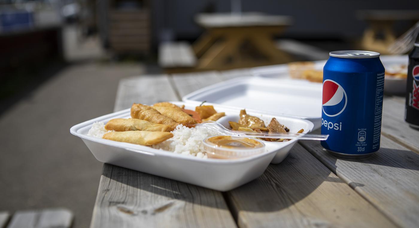 Thaimat ligger serverat i en matlåda på ett picknickbord.