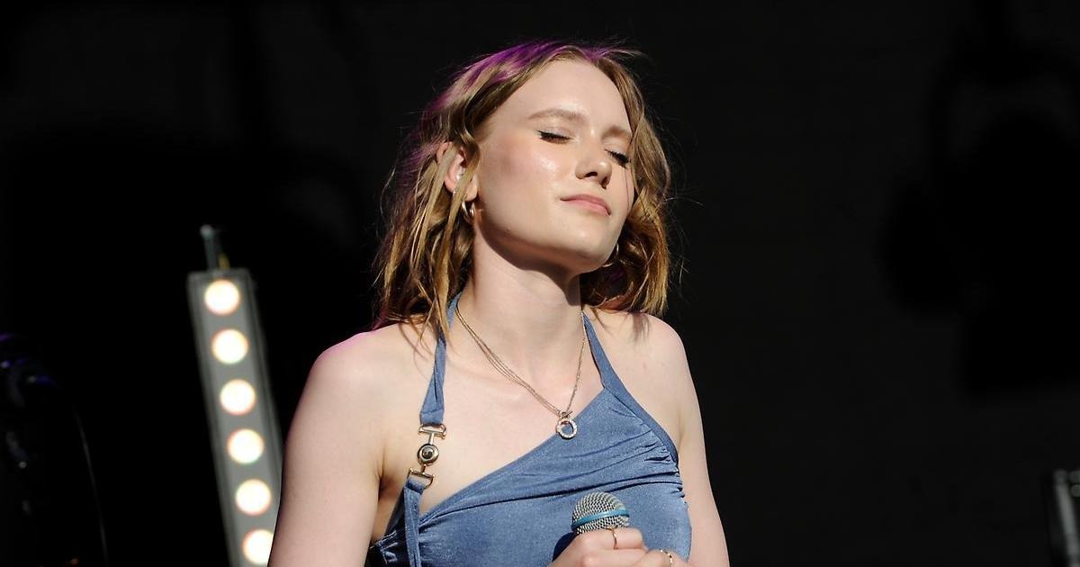 Nellie Pop på scen med mick i hand och slutna ögon