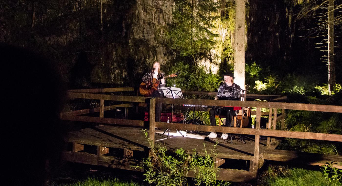 Två personer spelar gitarr och piano i en upplyst gruva