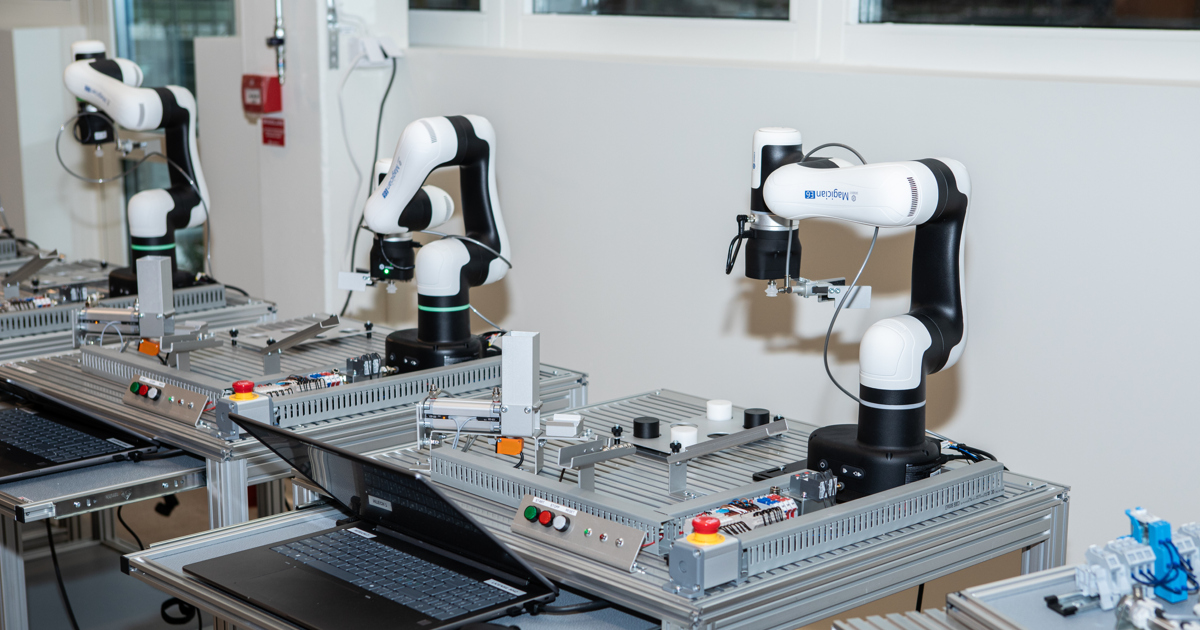 Tre robotar på rad vid olika arbetsstationer.